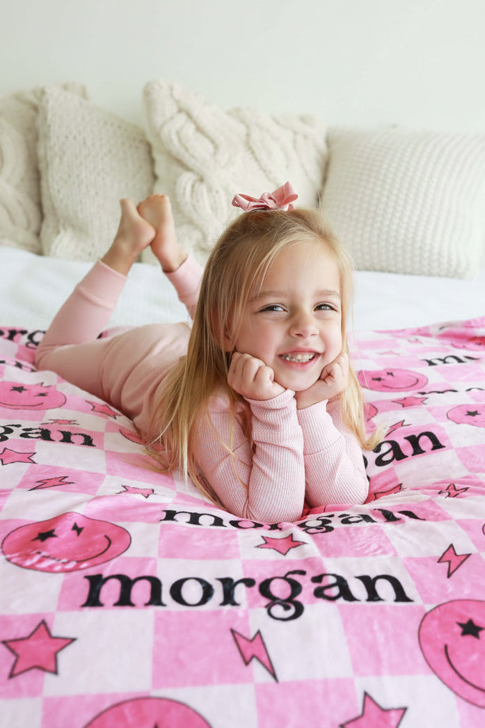 pink checkered blanket for kids with smiley faces