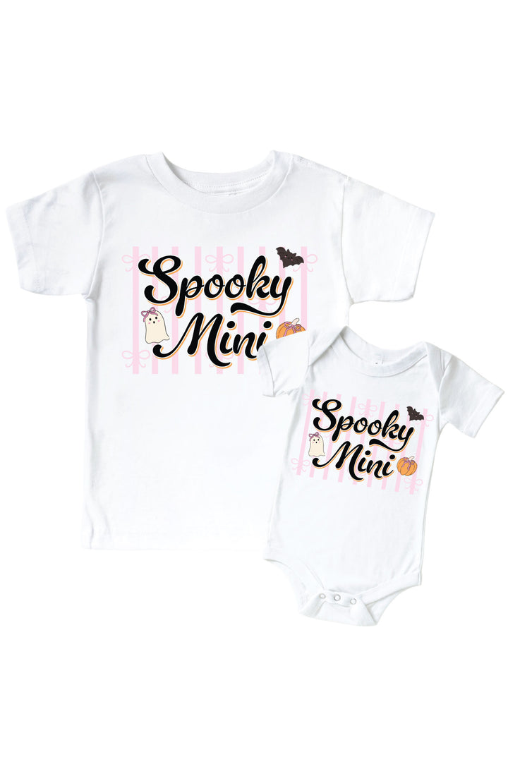 Matching white kids' t-shirt and baby bodysuit, both printed with 'Spooky Mini' text and Halloween graphics of a pumpkin, bat, and ghost.