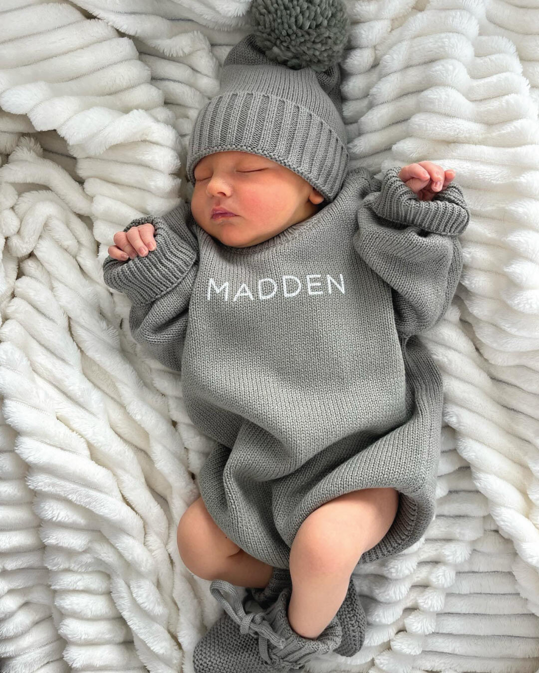 Baby wearing a Personalized Printed Knit Sweater Bubble in the color Smoke, with matching hat & booties