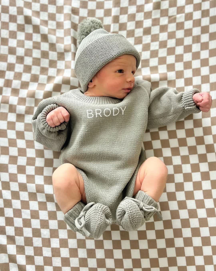 Baby wearing a Personalized Printed Knit Sweater Bubble in the color Smoke, with matching hat & booties