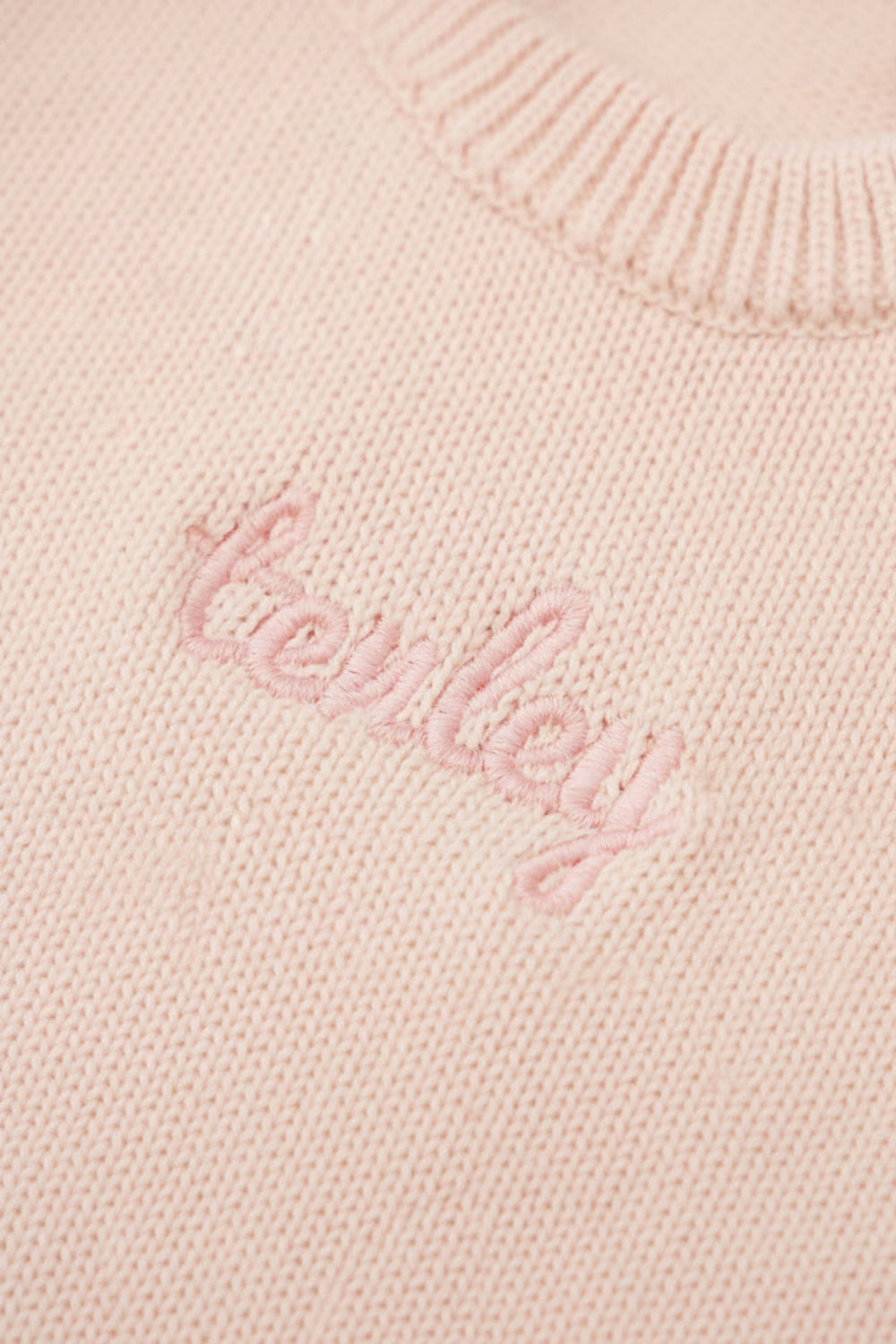 tea rose long sleeve knit sweater romper with light pink thread in script font 