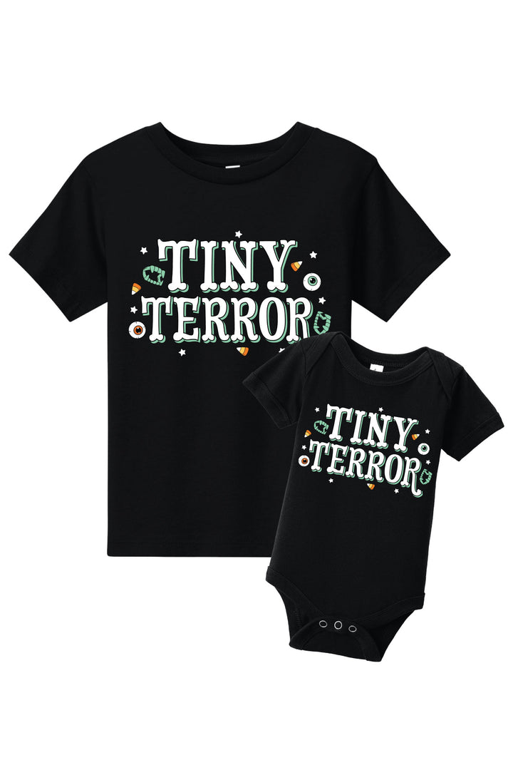 Black t-shirt and baby bodysuit with 'Tiny Terror' text on a white background