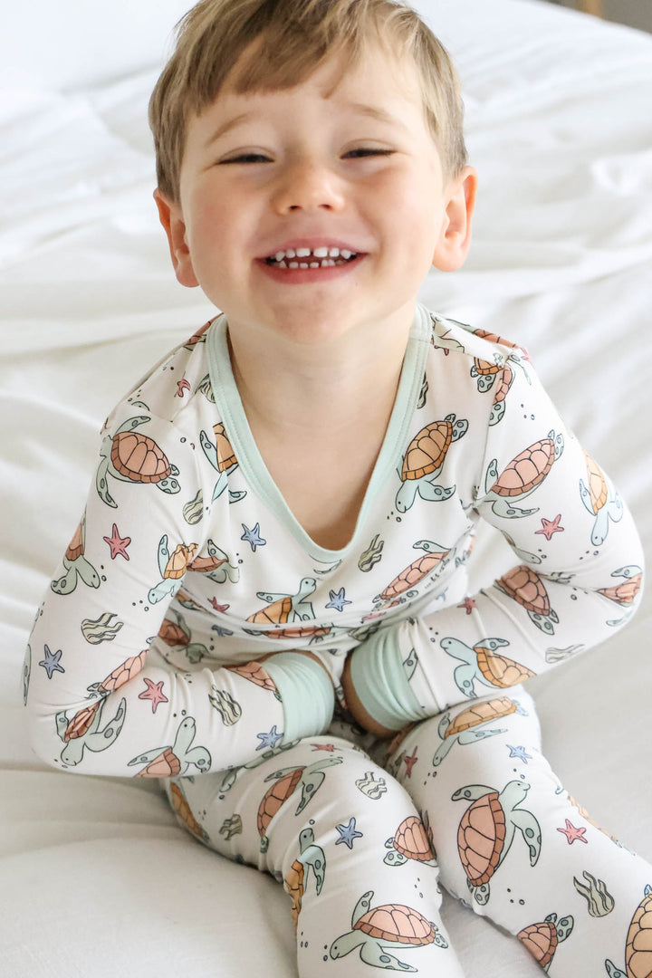 turtley rad bamboo two piece pajamas on a baby – gender neutral turtle print
