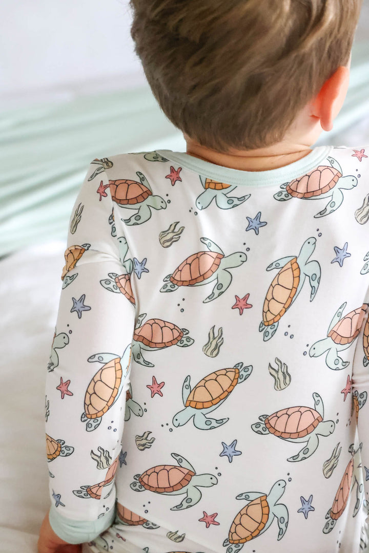 turtley rad bamboo two piece pajamas on a baby – gender neutral turtle print