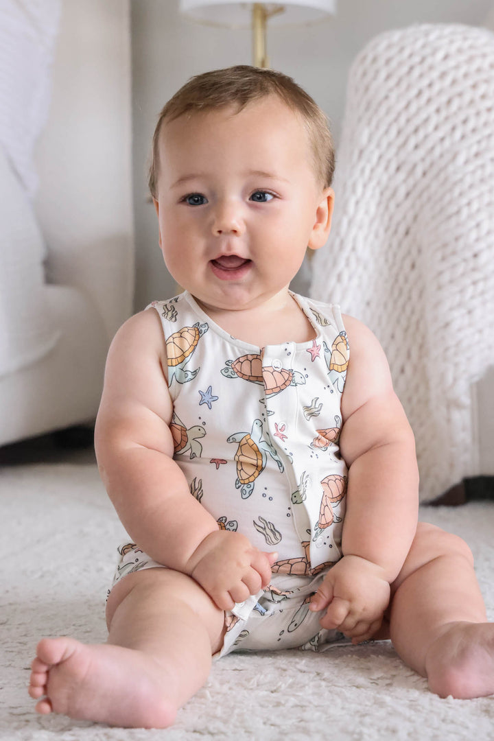 turtley rad bamboo sleeveless snap romper on a baby – gender neutral turtle print