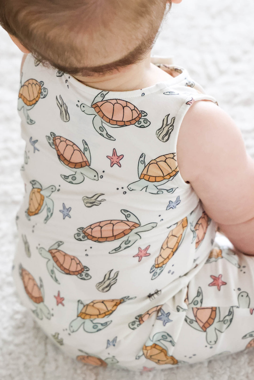 turtley rad bamboo sleeveless snap romper on a baby – gender neutral turtle print