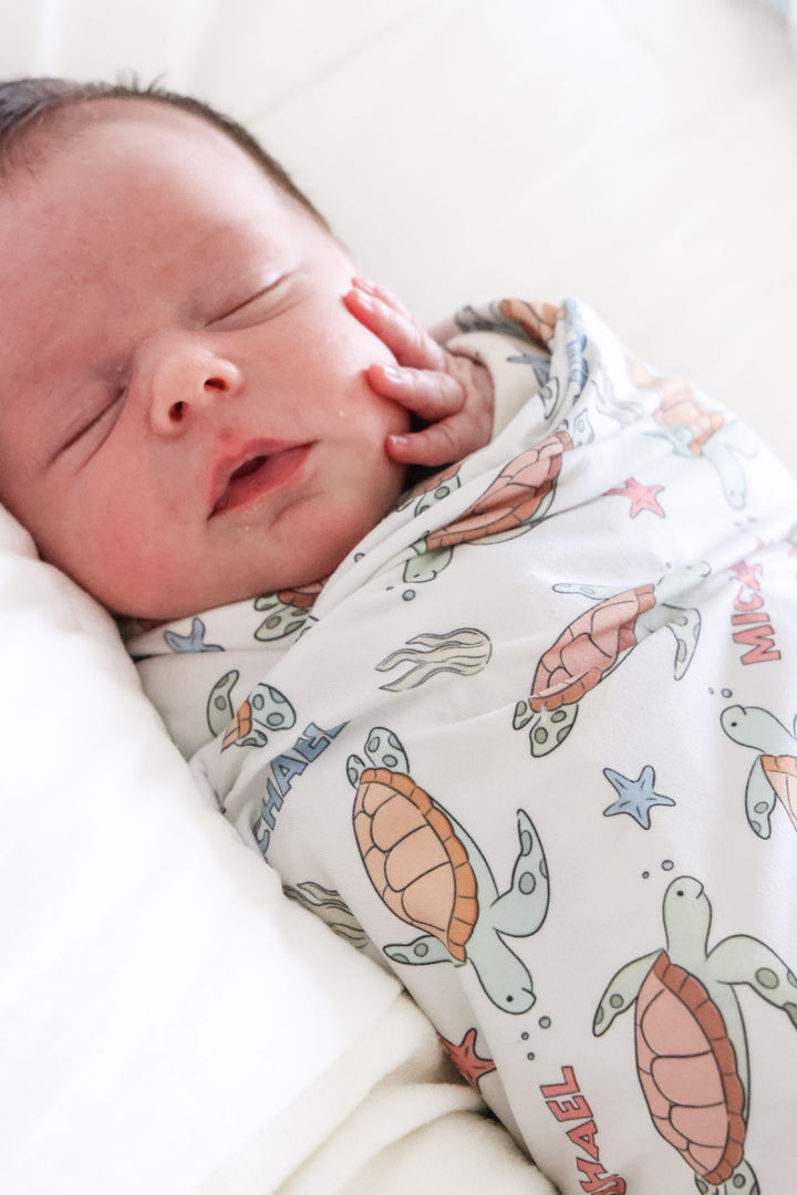 personalized swaddle blanket with turtley rad turtle print – lifestyle photo