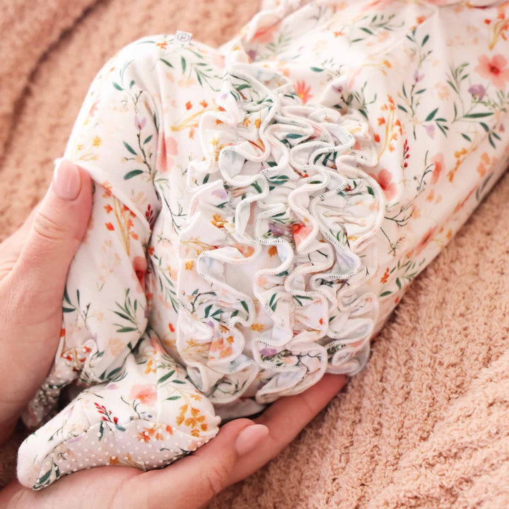 ruffle bottom zip footie for newborn in soft pastel floral print