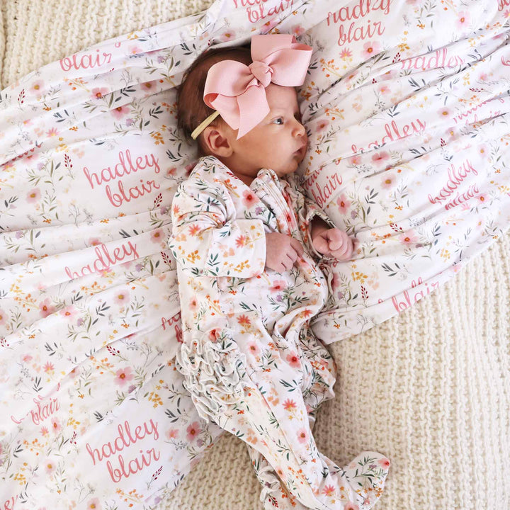 baby wearing zip footie with ruffle bottom in girly floral print