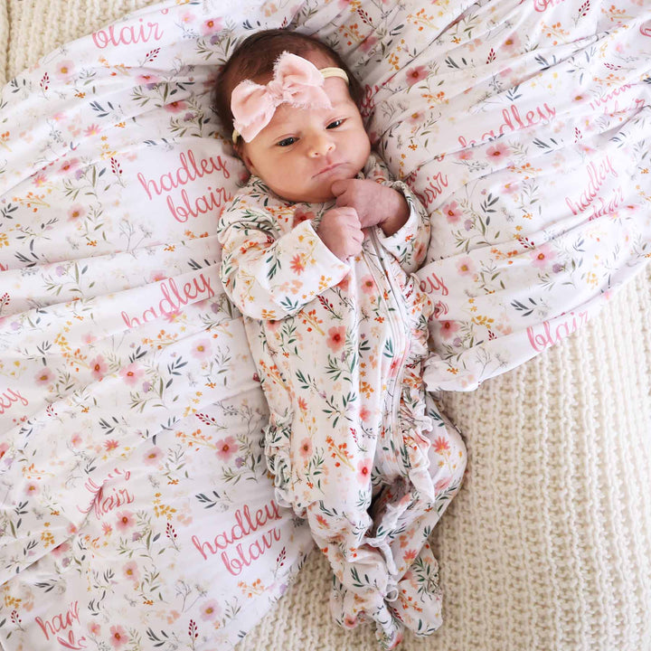 newborn baby girl wearing sleep romper in dainty floral print with ruffles