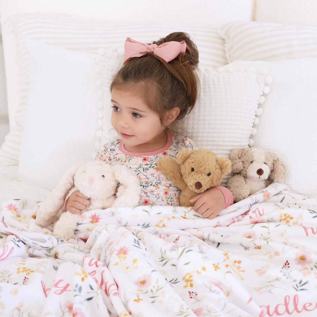 girl wearing dainty floral printed pajamas with matching personalized blanket 